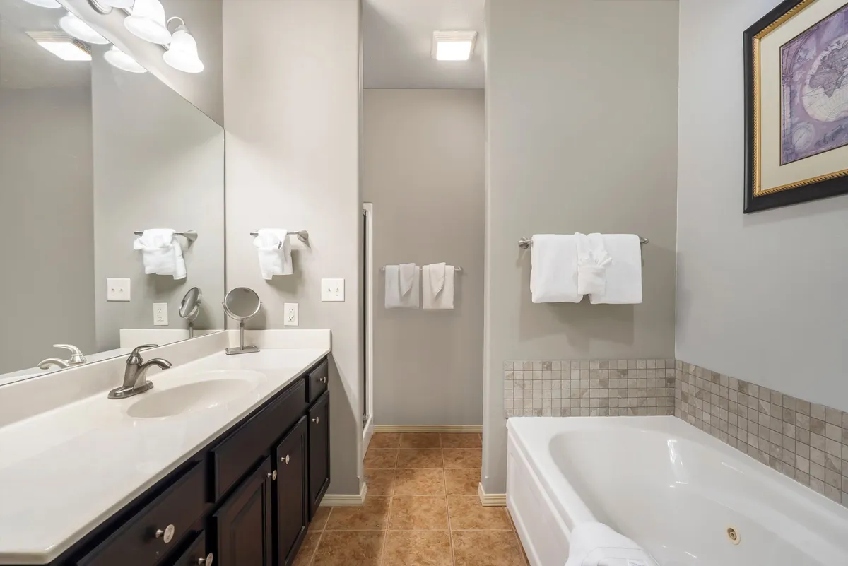 A serene, spa-like bathroom featuring a double sink vanity, large soaking tub, and framed artwork. The space is bright, organized, and designed for relaxation, setting the scene for a luxurious soak or morning routine.