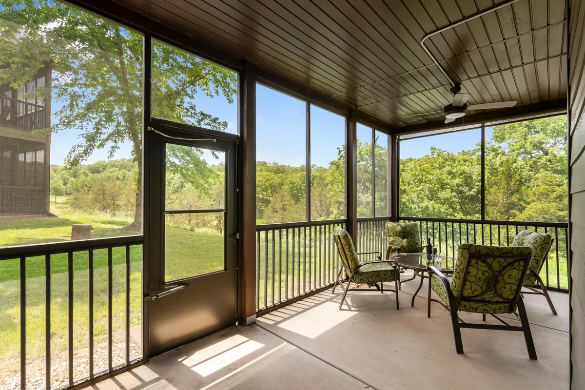A tranquil screened-in porch with decorative chairs and a small table, overlooking lush greenery outside. The space feels peaceful and connected to nature—perfect for morning coffee or evening relaxation, as described in the section.